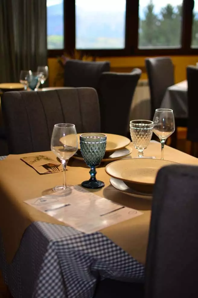 Mesa puesta junto a los ventanales del comedor de Casa La Nicia