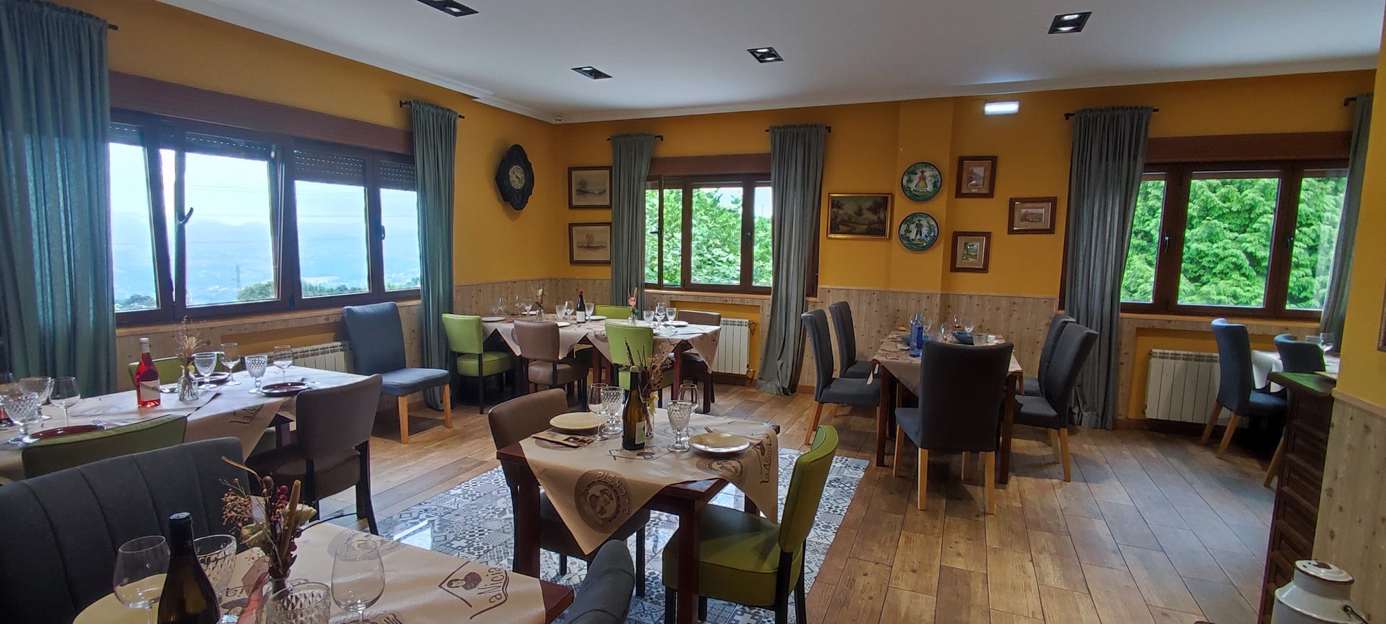 Comedor de Casa La Nicia con mesas puestas y ventanales al valle